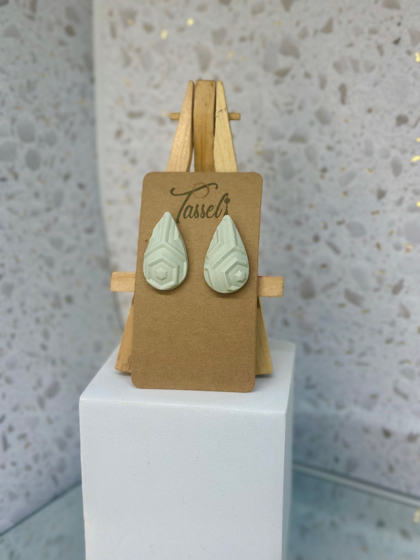 Aztec Teardrops polymer clay stud earrings in muted bluish-grey with large teardrop shape and geometric detailing.