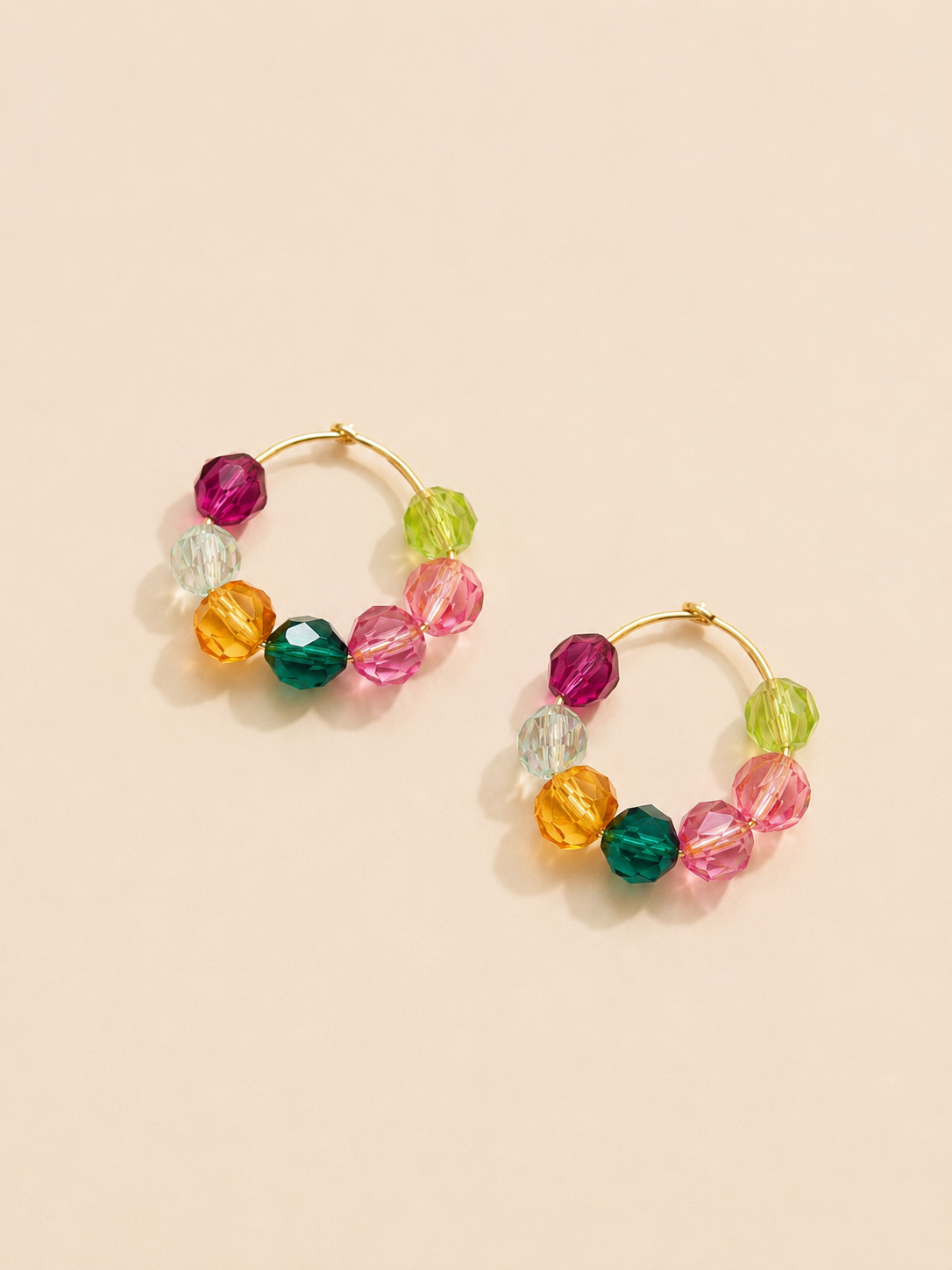 Colorful beaded hoop earrings with pink, green, yellow, teal, and iridescent crystal-style beads by Tassel Bermuda.