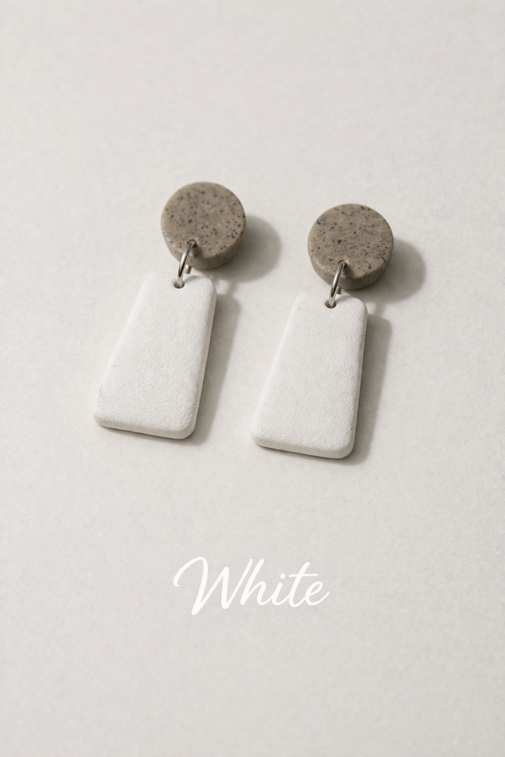 White earrings with brown circular tops on a white background