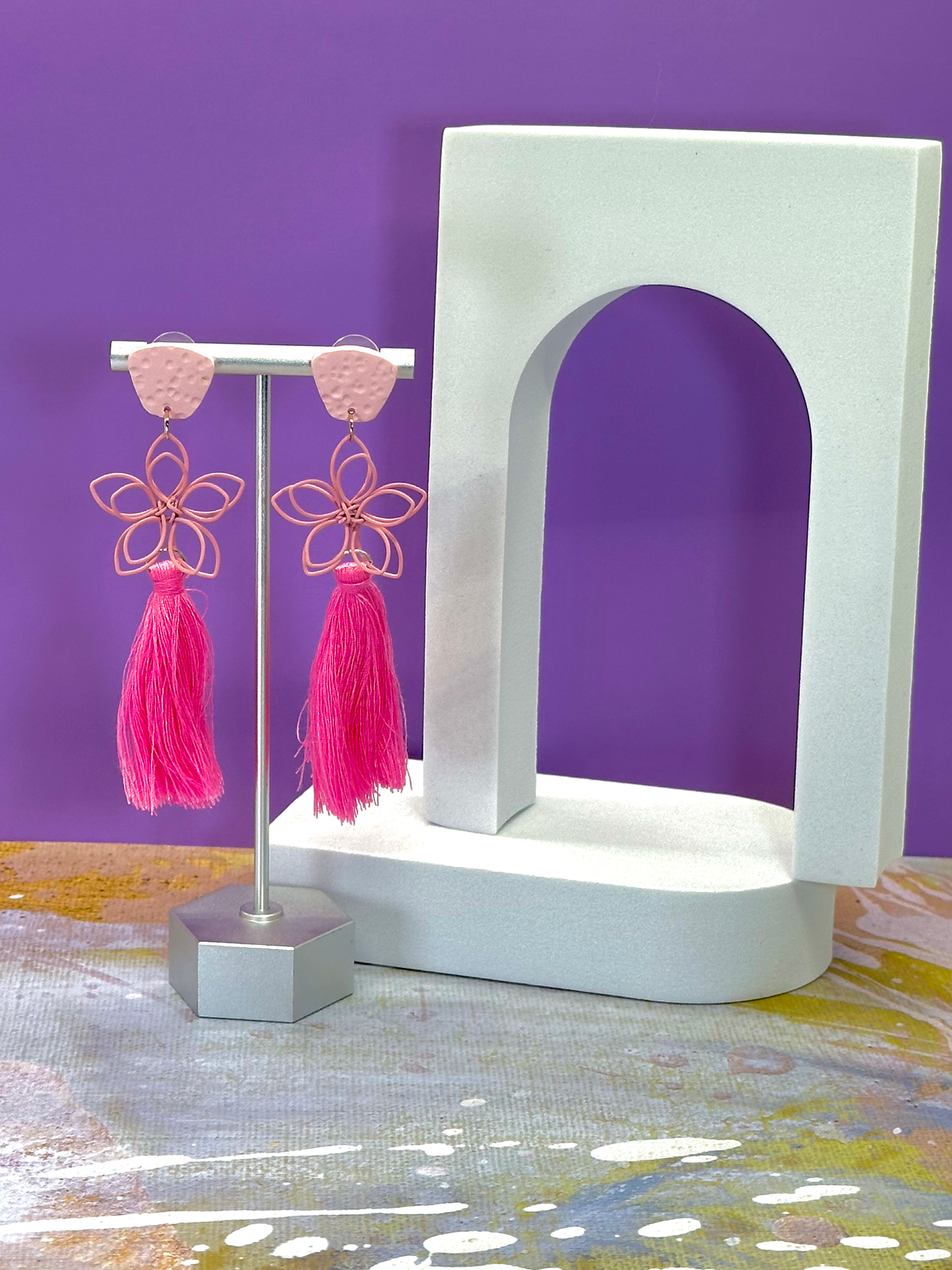 Flora tassel earrings featuring a delicate wire flower embellishment, bold polymer clay accents, and bright tassels in vibrant colors.