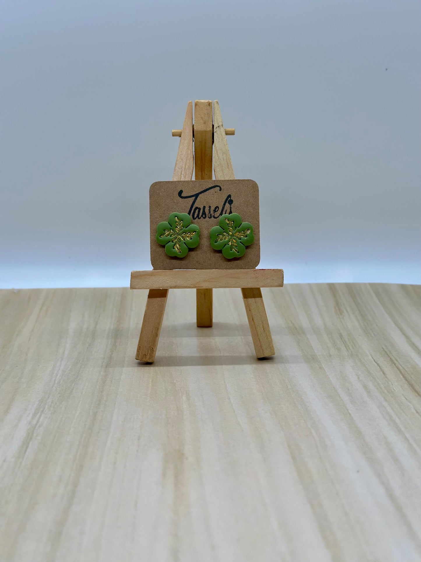 Lucky polymer clay stud earrings shaped like four-leaf clovers with shimmering gold details, perfect for St. Patrick’s Day.