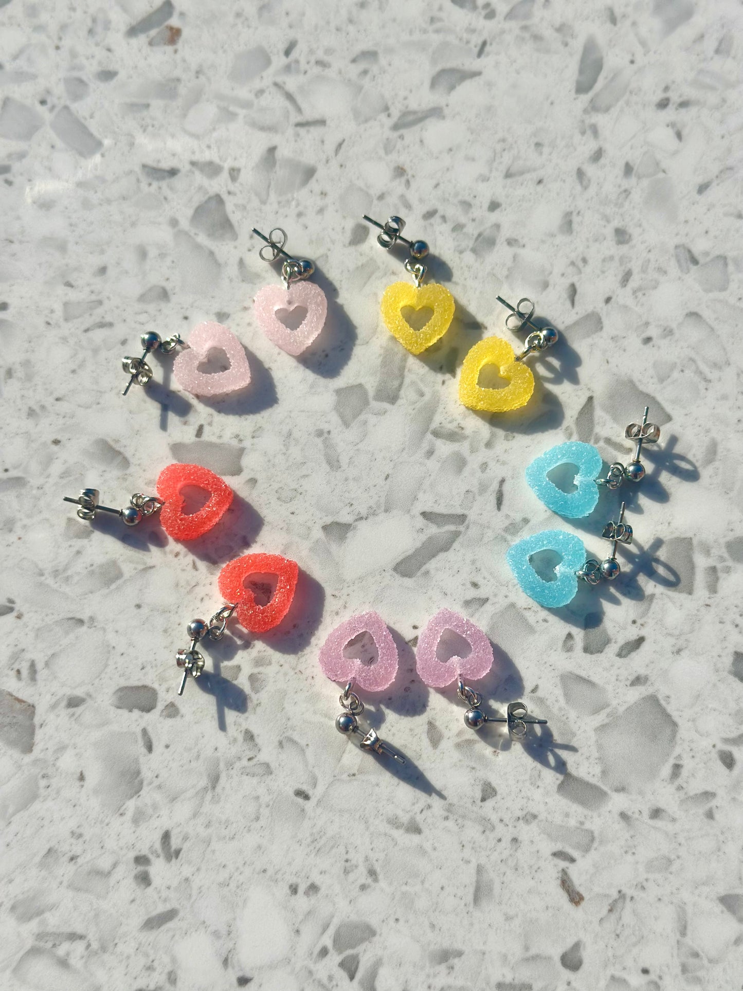 Whimsical heart-shaped dangle earrings with a playful frosted look