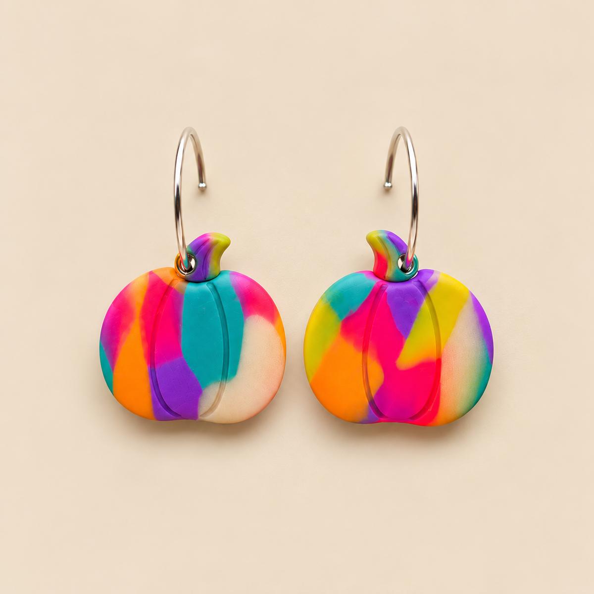 Glow-in-the-dark polymer clay pumpkin hoop earrings with cobweb texture handcrafted by Tassel Bermuda