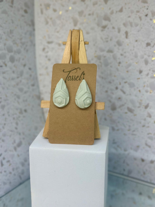 Aztec Teardrops polymer clay stud earrings in muted bluish-grey with large teardrop shape and geometric detailing.