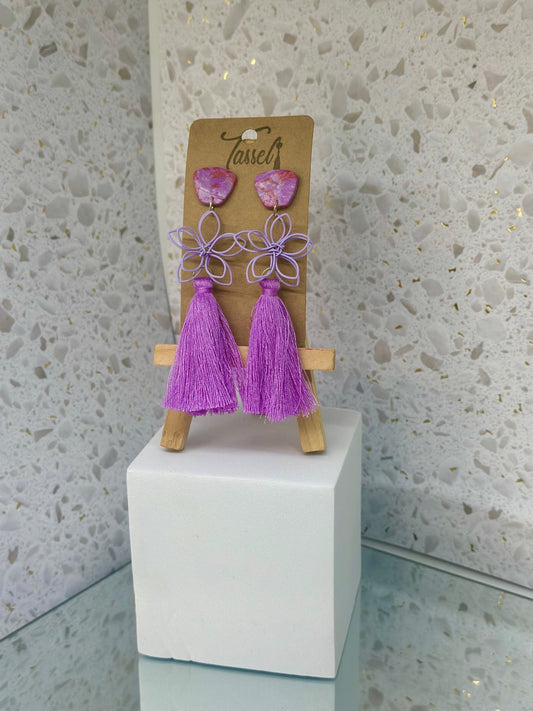 Flora tassel earrings featuring a delicate wire flower embellishment, bold polymer clay accents, and bright tassels in vibrant colors.
