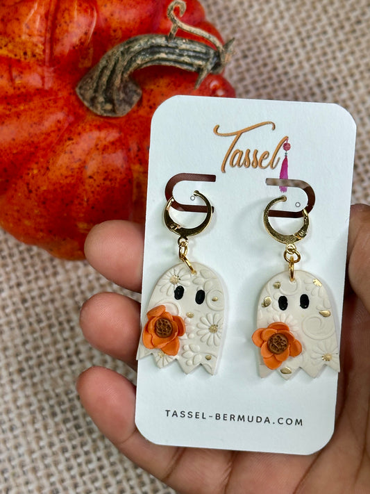Ghosted polymer clay dangle earrings shaped like cute white ghosts with embossed floral texture, gold accents, and orange flower details.