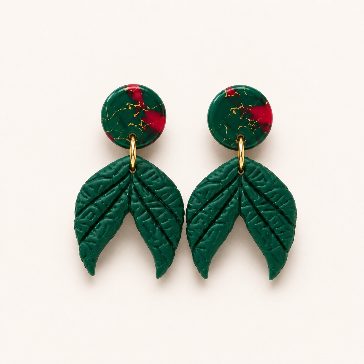 Handmade Jubilee green polymer clay dangle earrings with marbled holiday studs and textured botanical leaf charm in evergreen.