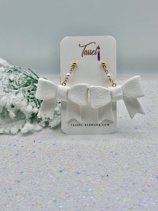 White bow-shaped earrings on a Tassel branded card with a light gray background