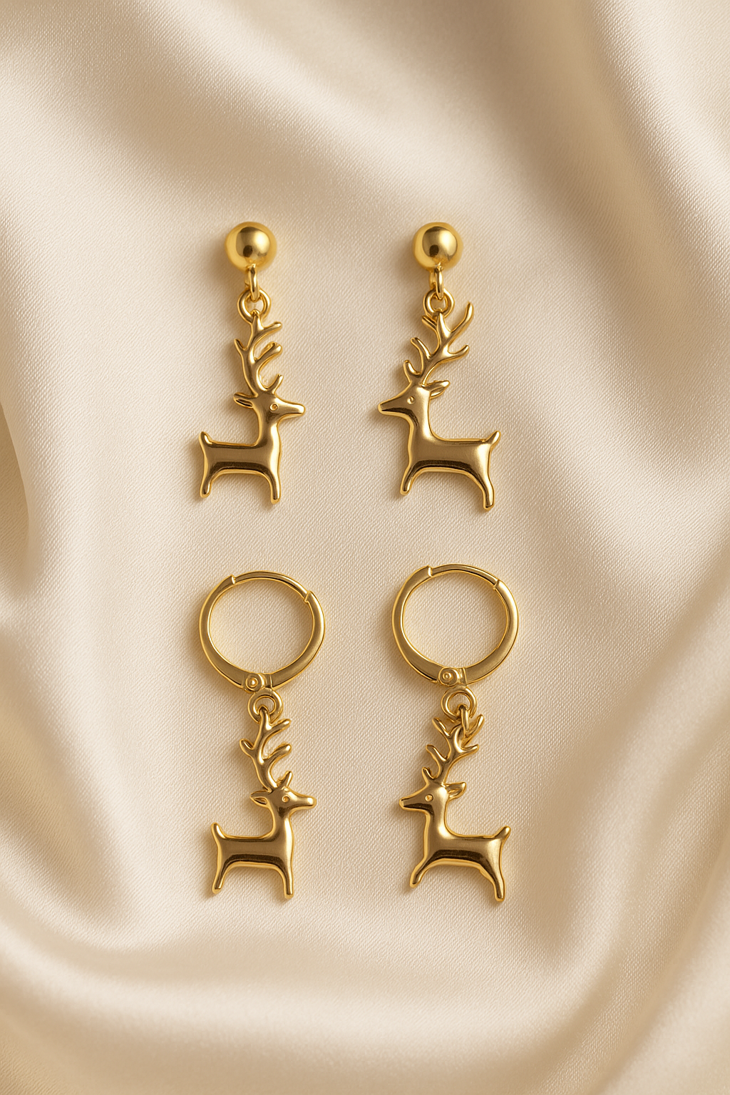 Gold deer-shaped earrings on a beige fabric background