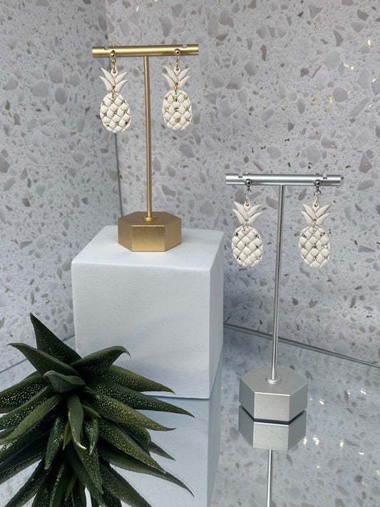 Pineapple-shaped polymer clay dangle earrings with shimmering gold or silver shattered stone embellishments, inspired by tropical island style.