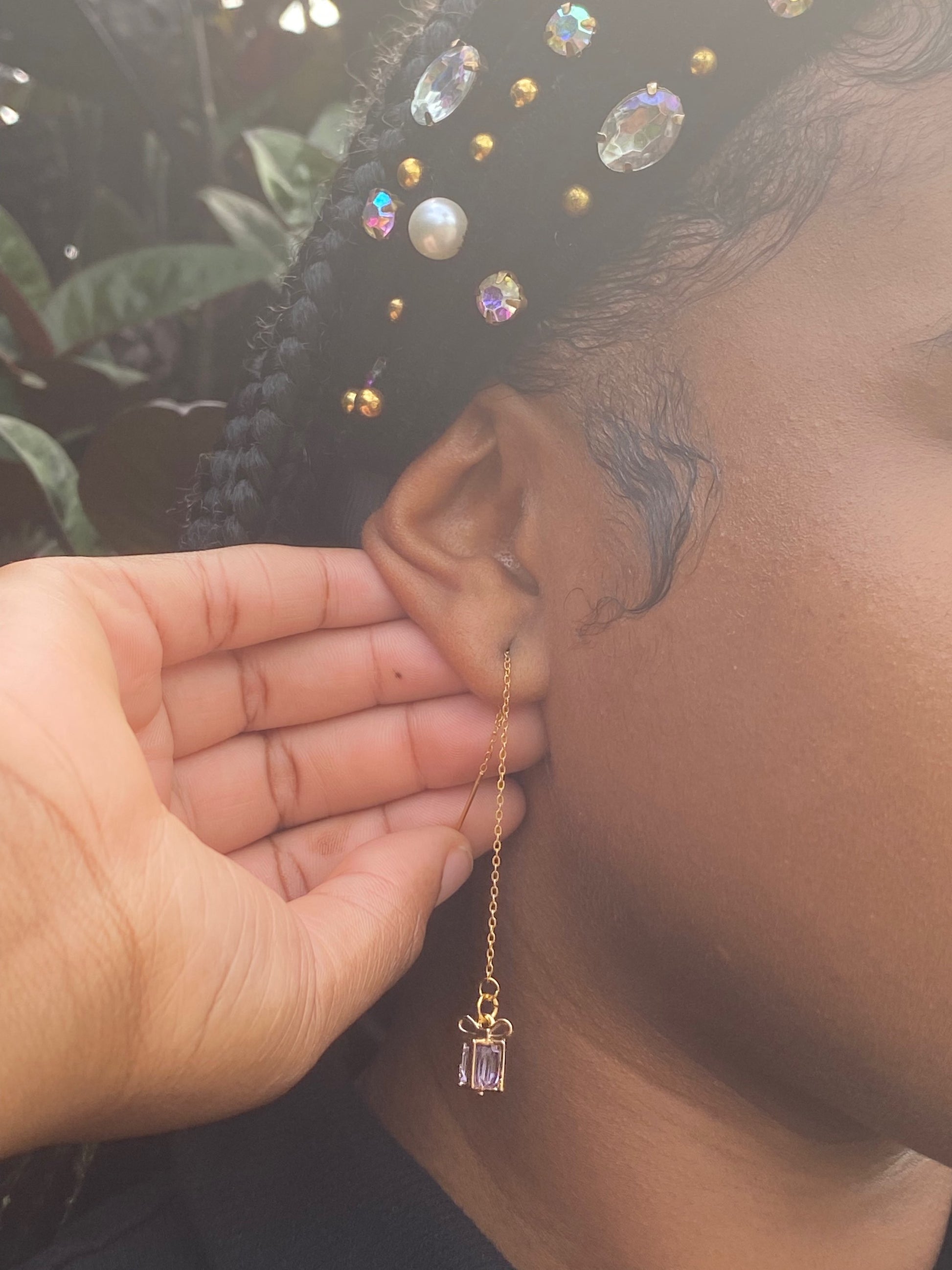 Model wearing Treasure threader earrings featuring gold gift box pendants with colorful red gemstone center, designed for holidays and birthdays.