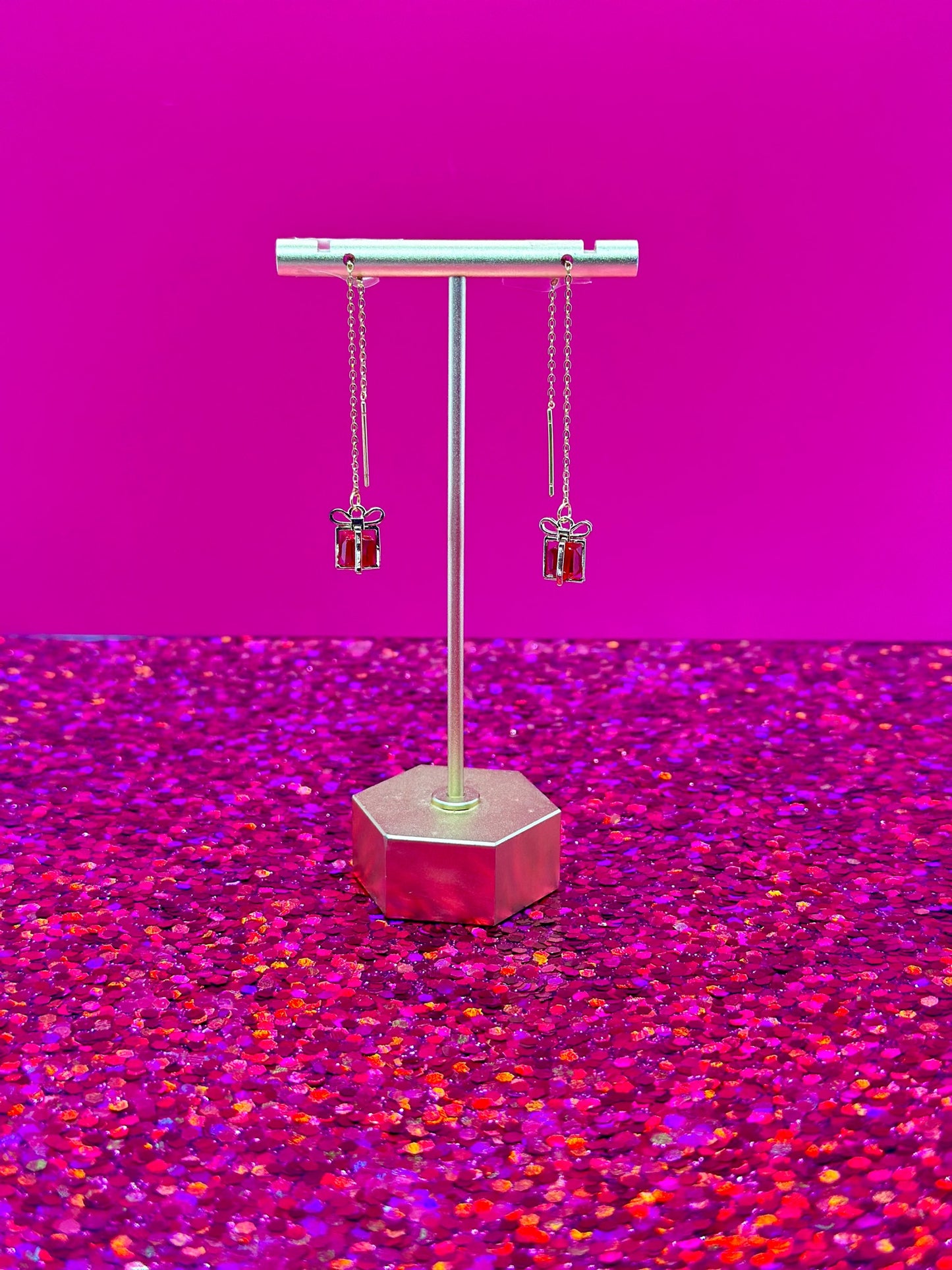 Treasure threader earrings featuring gold gift box pendants with colorful red gemstone center, designed for holidays and birthdays.